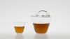 TEA BAG. Théière avec poignée décentrée en verre massif. Bouchon en verre.<br />Dimensions : diamètre 130mm, hauteur 150mm. Contenance 75cl. <br />Bols assortis empilables : diamètre 78mm.<br /><br />Crédit photographique : Xavier Nicostrate. - Laurence Brabant Alain Villechange