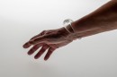 Poetic element of reverie and play like a child, this glass bangle mixes liquid and gas. The air bubble floats in the liquid and navigates according to the movements of the wrist. Far from a mechanical aesthetic, each piece, unique, requires great dexterity for its manufacture. Sculpted without mold each piece will be of an identical aesthetic but slightly variable dimensions. Easy to wear and adopt.<br />Photo credit : Xavier Nicostrate. - Laurence Brabant Alain Villechange