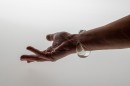 Poetic element of reverie and play like a child, this glass bangle mixes liquid and gas. The air bubble floats in the liquid and navigates according to the movements of the wrist. Far from a mechanical aesthetic, each piece, unique, requires great dexterity for its manufacture. Sculpted without mold each piece will be of an identical aesthetic but slightly variable dimensions. Easy to wear and adopt.<br />Photo credit : Xavier Nicostrate. - Laurence Brabant Alain Villechange